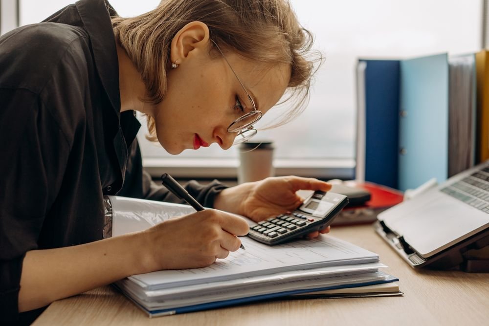 Femme travaillant sur la comptabilité avec des documents