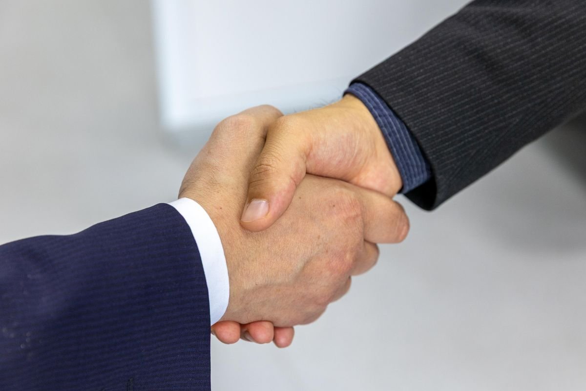 Executives shaking hands after closing an acquisition deal