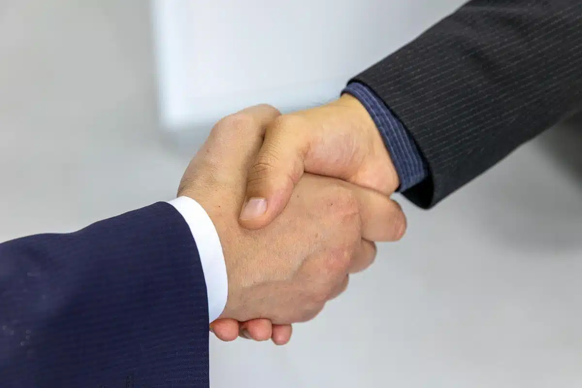 Executives shaking hands after closing an acquisition deal