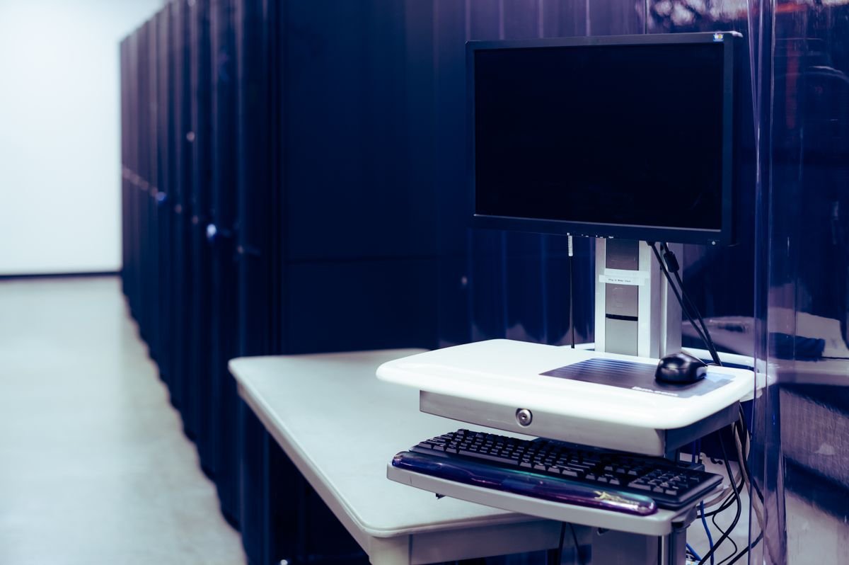 IT workstation next to server racks during systems consolidation