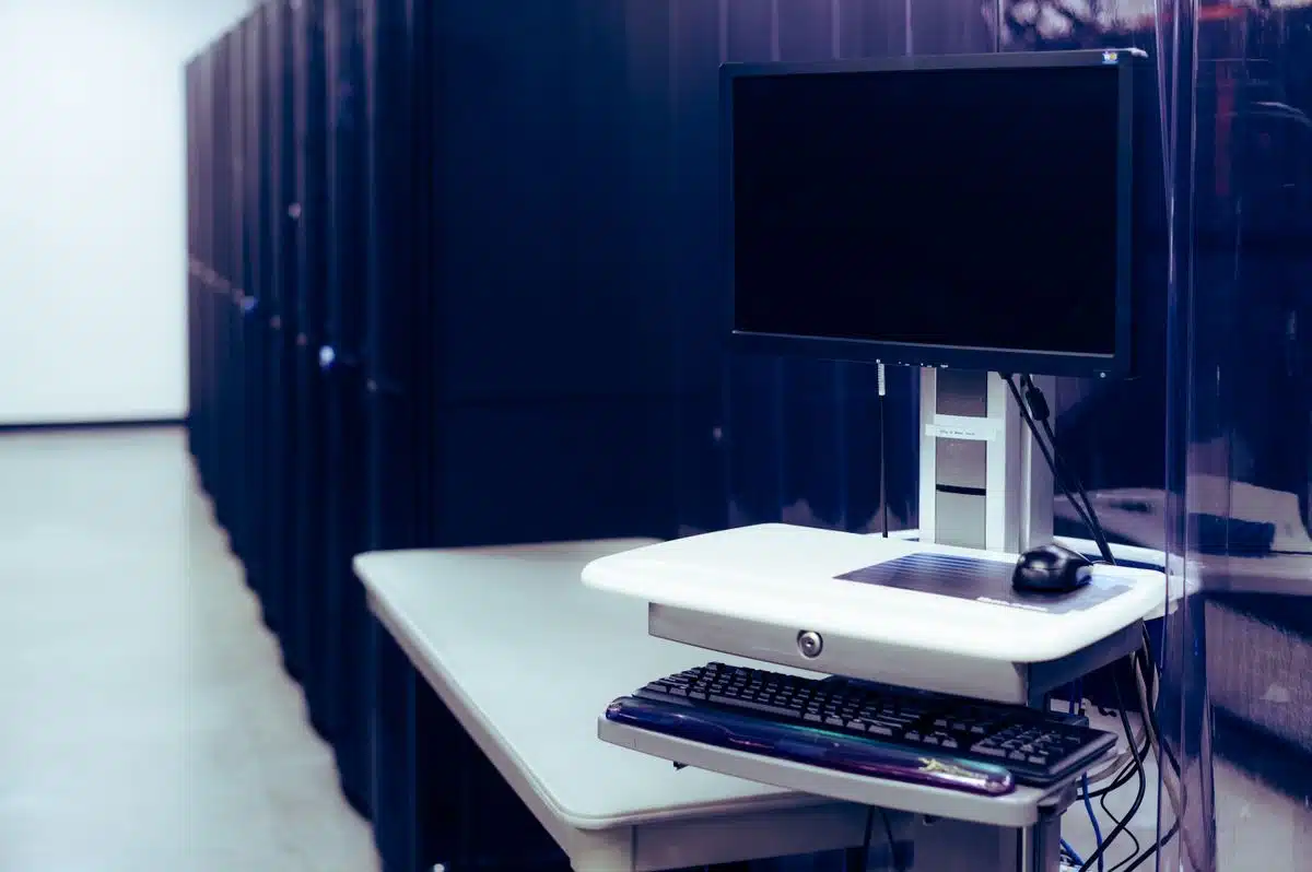 IT workstation next to server racks during systems consolidation