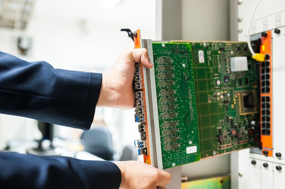 Engineer installing a circuit board in a server rack, illustrating system migration and upgrade Notoriti