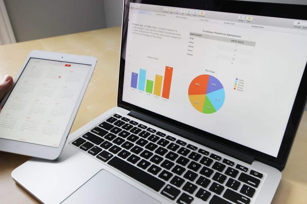 Ordinateur portable affichant des graphiques de données à côté d'un calendrier de planification, illustrant le cadrage produit d'un projet ERP