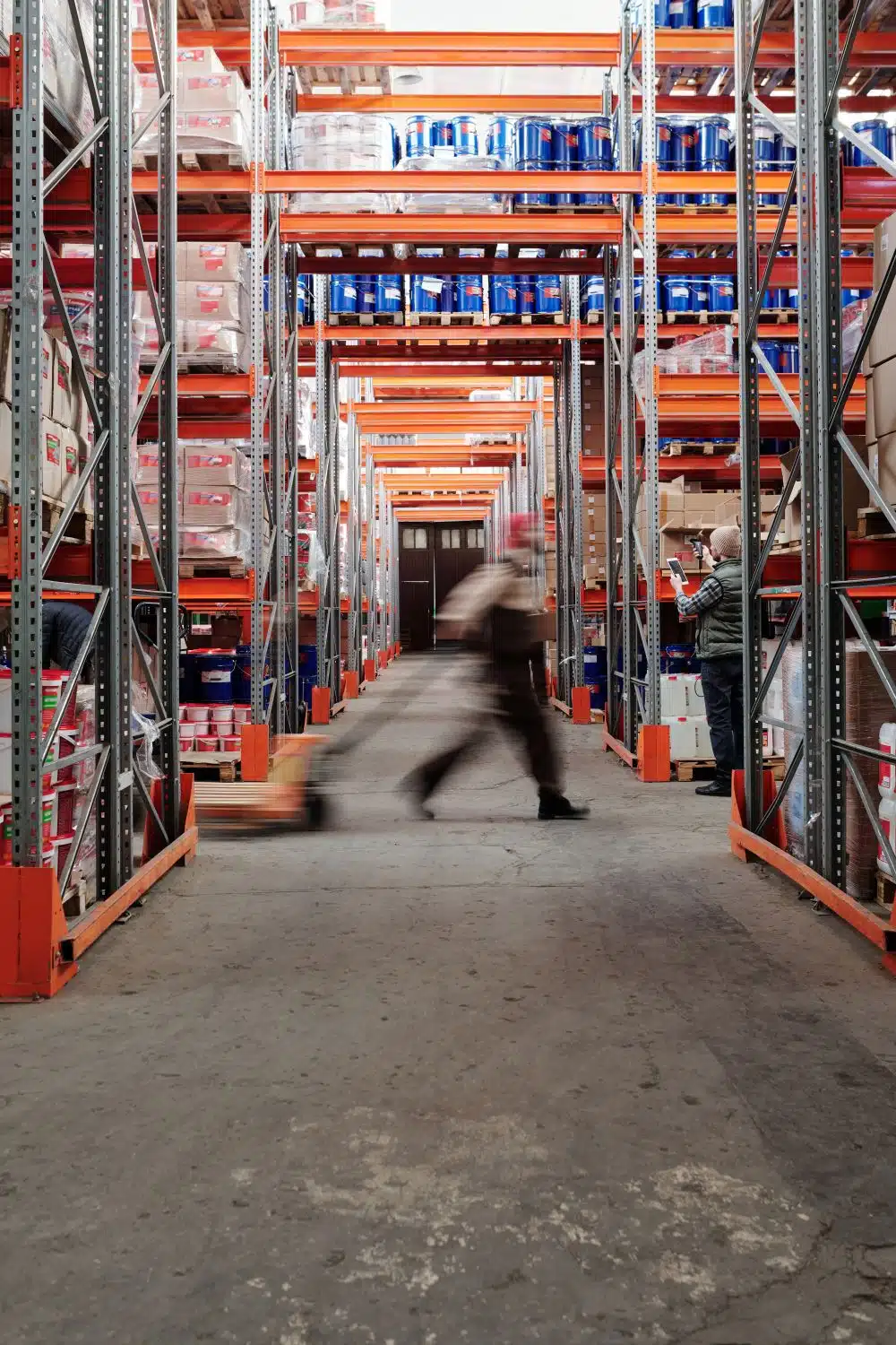 Worker walking through a spacious warehouse aisle, illustrating agentic AI supply chain operations
