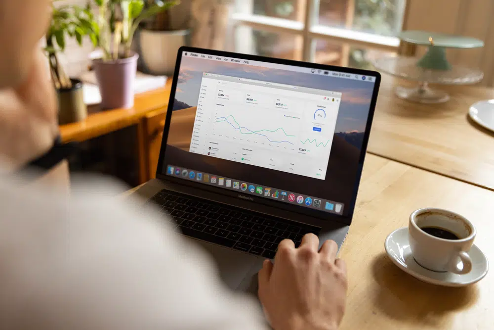Person analyzing business data on a laptop, illustrating the Product Owner's review of Copilot-generated outputs