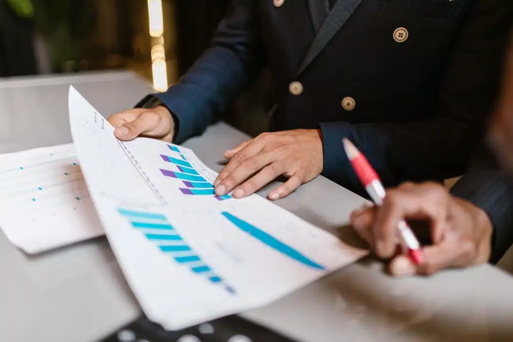 Professionnels examinant des graphiques financiers lors d'une réunion, illustrant la gouvernance et la validation humaine des agents Copilot