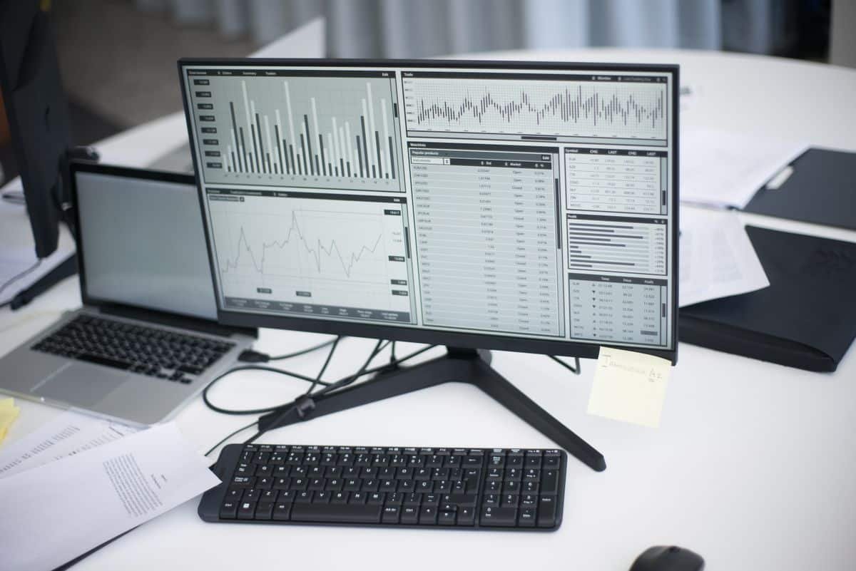 Poste de travail professionnel avec écrans affichant des graphiques analytiques, illustrant le cadrage d'un déploiement Copilot dans Dynamics 365 - Notoriti